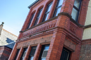 A red-brick building with an arched entrance, bearing the inscription Conservative Club above the door. The corner of the Oxton Conservative Club displays the year 1897 in raised lettering.