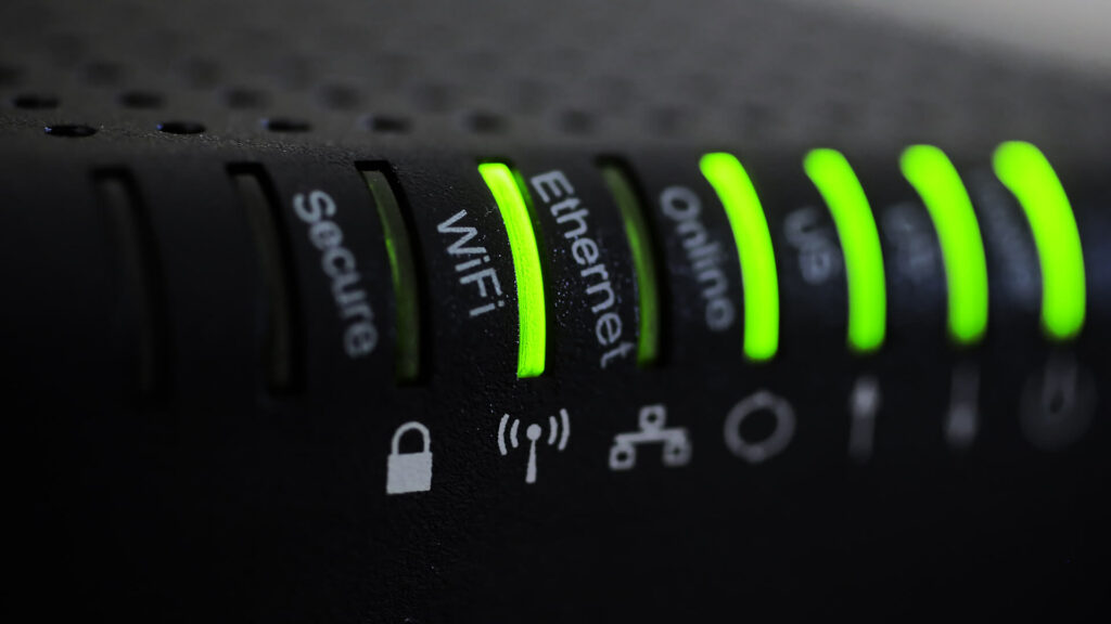 Close up of a WIFI router with gowing green lights