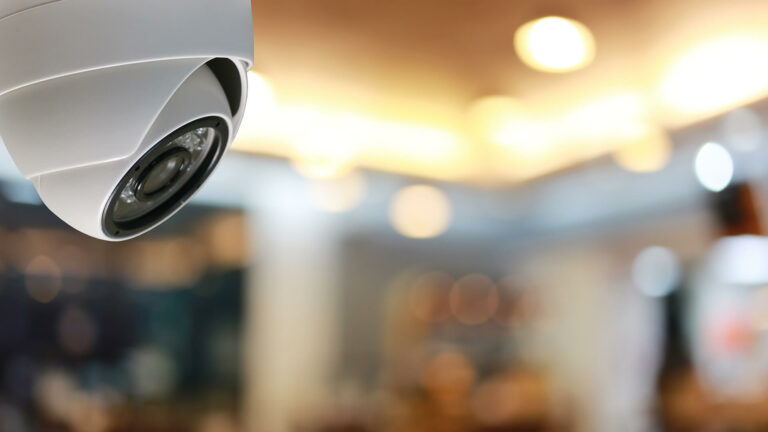 CCTV camera in the top right with a blured background on a bar