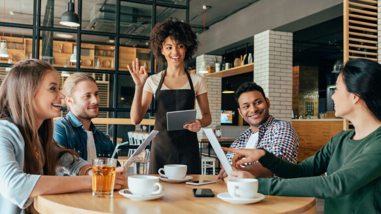 Waitress taking orders from clients in cafe