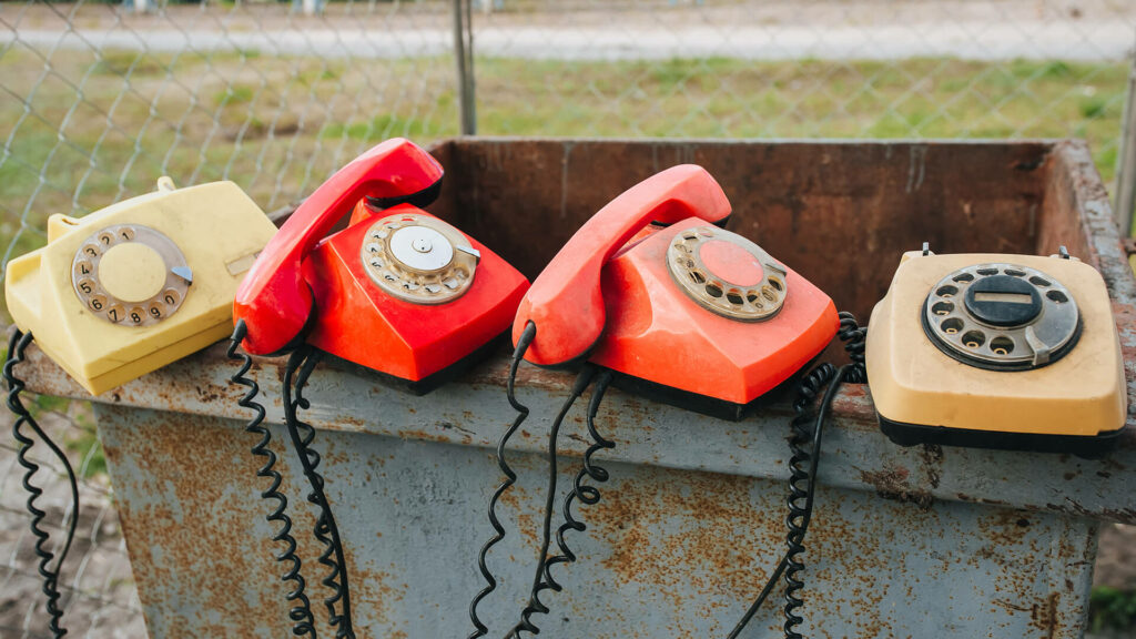 Old phones sat on a rubbish bin